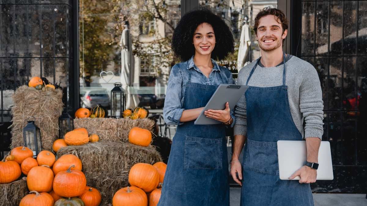 Male and Female small business owners at Autumn harvest selling pumpkins